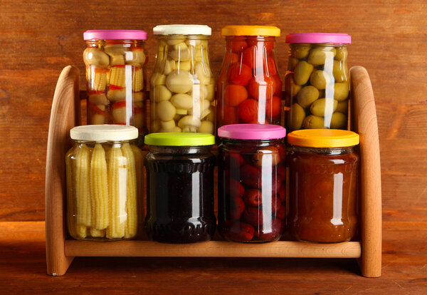 Different conservations on shelves on wooden background