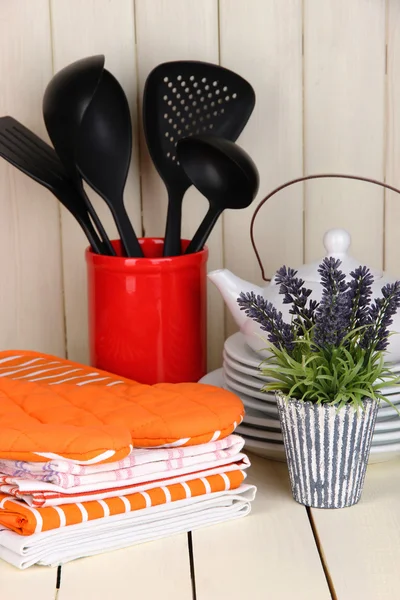 Kitchen settings: utensil, potholders, towels and else on wooden table — Stock Photo, Image