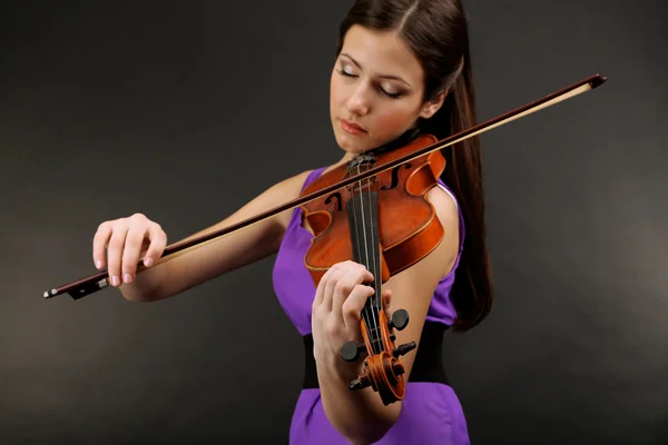 Красивая молодая девушка со скрипкой на сером фоне — стоковое фото