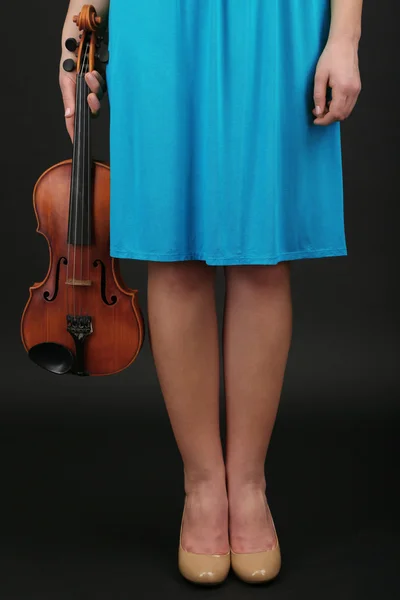 Молодая девушка со скрипкой на сером фоне — стоковое фото