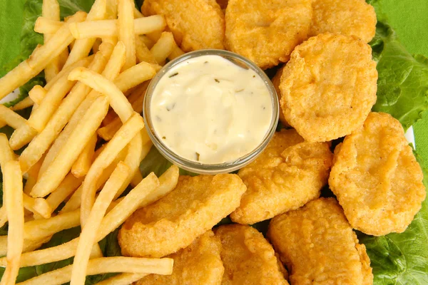 Fried chicken nuggets with french fries and sauce close-up — Stock Photo, Image