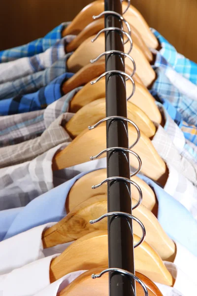 Men's shirts on hangers in wardrobe