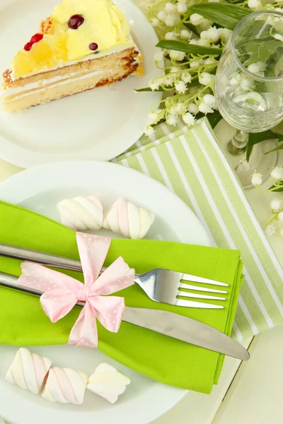 Tischdekoration in weißen und grünen Tönen auf farbigem Holzhintergrund — Stockfoto