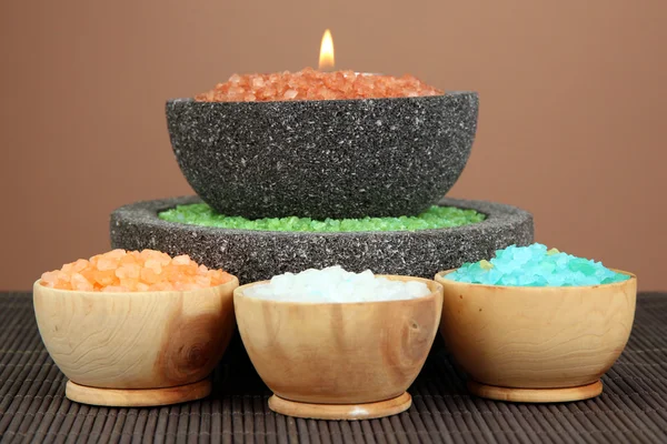 Candle in stone bowl with marine salt, on bamboo mat, on brown background — Stock Photo, Image