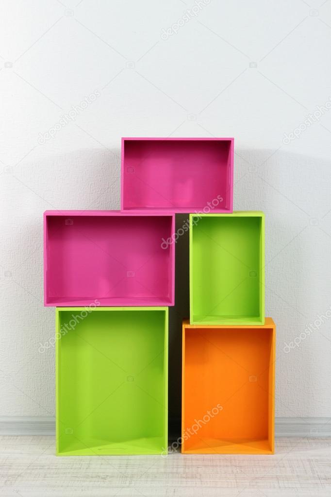 Beautiful colorful crates as shelves standing in room