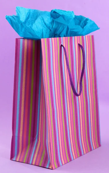 Striped shopping bag on purple background — Stock Photo, Image