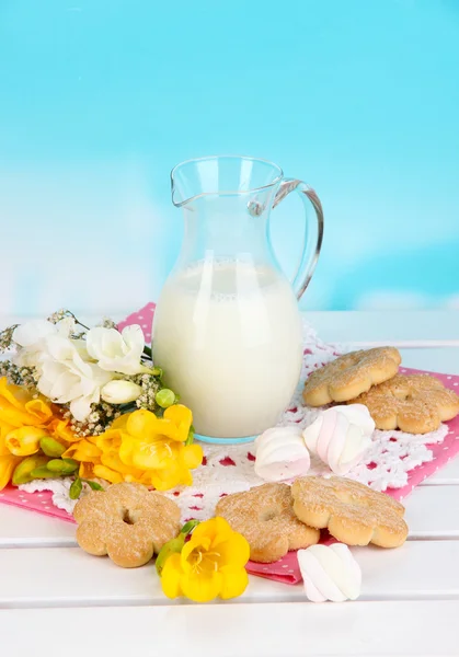 Bela composição de leite e biscoitos na mesa de piquenique de madeira no fundo natural — Fotografia de Stock
