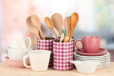Cups, bowls nd other utensils in metal containers isolated on light background