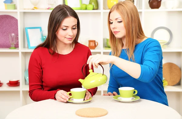 Iki kız arkadaş konuşmak ve mutfakta çay içmek — Stok fotoğraf