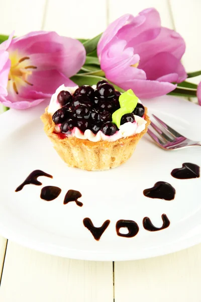 Süße Torte mit Brombeer- und Schokoladensauce auf Teller, auf Holzgrund — Stockfoto