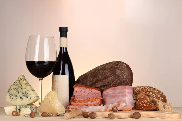 Exquisito bodegón de vino, queso y productos cárnicos — Foto de Stock