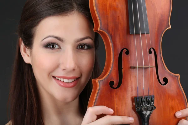 Beautiful young girl with violin on grey background — Stock Photo, Image