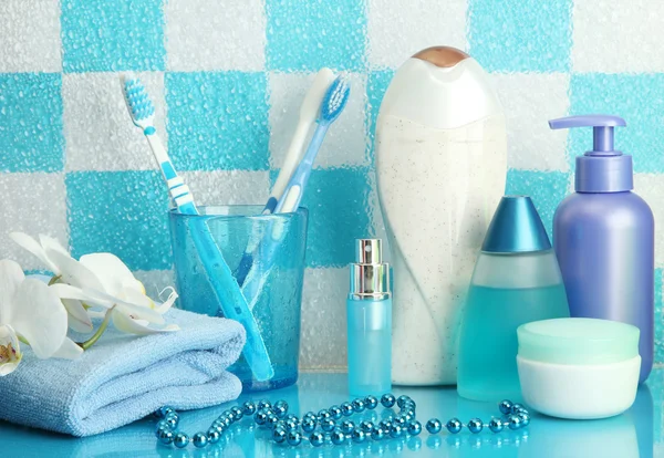 Accesorios de baño en el estante en el baño sobre fondo de pared de azulejo azul —  Fotos de Stock