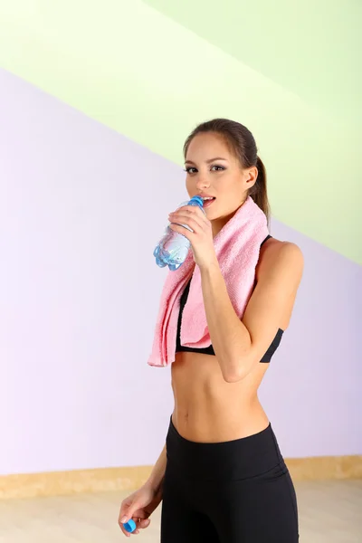 Young woman with water after workout at gym — Stock Photo, Image