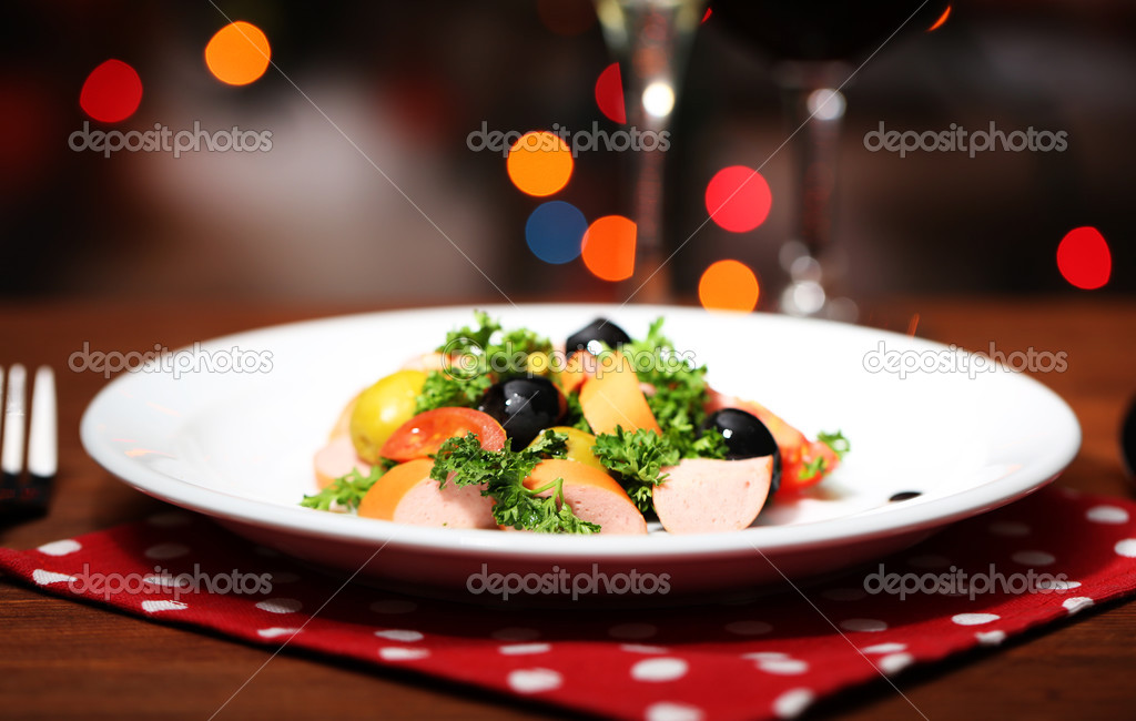 Tasty salad on dark background with bokeh defocused lights