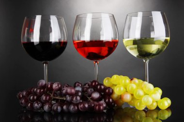 Assortment of wine in glasses on grey background clipart