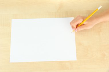 ahşap zemin üzerinde beyaz kağıt kalem ile el