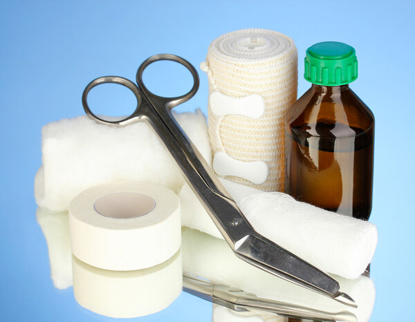First aid kit for bandaging on blue background