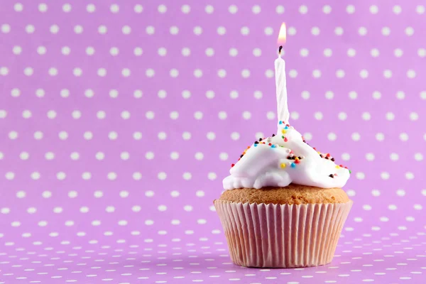 Cupcake de aniversário saboroso com vela, no fundo roxo — Fotografia de Stock