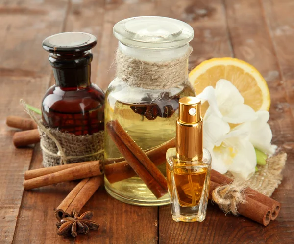 Garrafas com ingredientes para o perfume em fundo de madeira — Fotografia de Stock