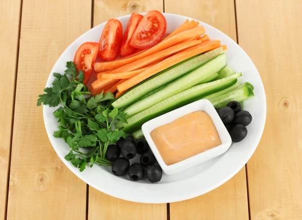 Bâtonnets de légumes crus assortis dans une assiette sur une table en bois fermer — Photo