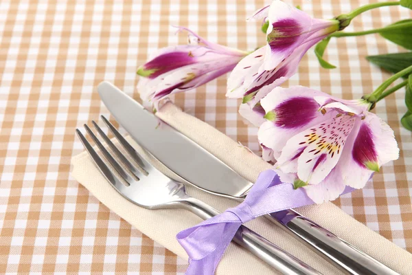 Tavolo da pranzo festivo con fiori su sfondo a scacchi — Foto Stock