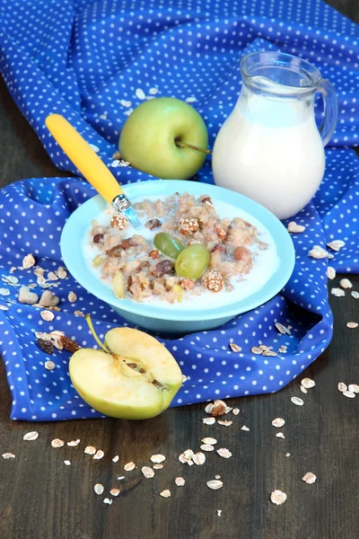 Nuttige havermout in kom met fruit op houten tafel close-up — Stockfoto