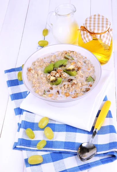 Farina d'avena utile in ciotola con frutta sul tavolo di legno primo piano — Foto Stock