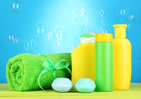 Kosmetyki dla dzieci, ręcznik i mydło na drewnianym stole, na niebieskim tle — Zdjęcie stockowe