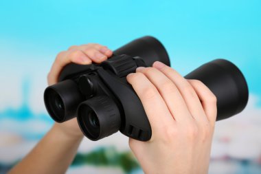 elinde mavi zemin üzerine siyah modern dürbün