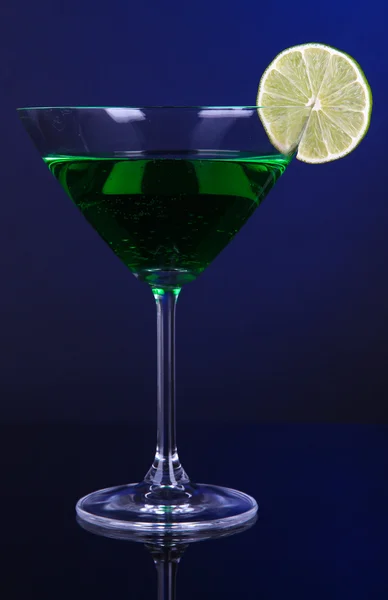 Groene cocktail in Martiniglas op donker blauwe achtergrond — Stockfoto