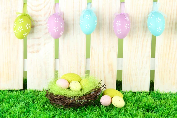 Art Easter background with eggs hanging on fence — Stock Photo, Image