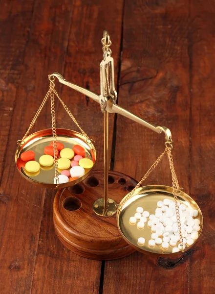 Классические весы с цветовыми таблетками на деревянном фоне — стоковое фото
