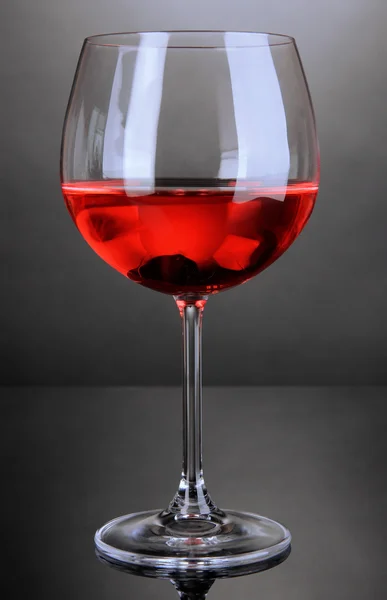 แก้วไวน์แดงบนพื้นหลังสีเทา — ภาพถ่ายสต็อก