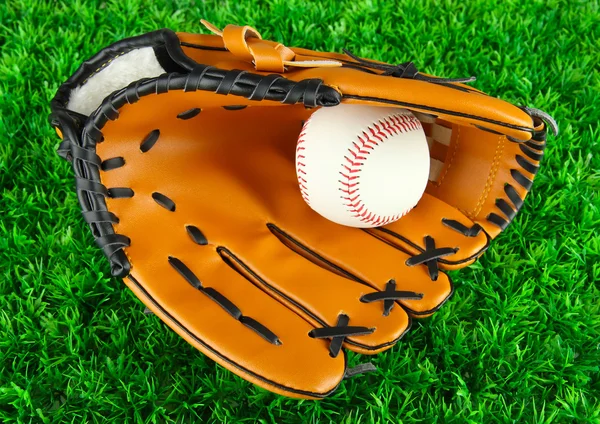 Baseball handske och bollen på gräs bakgrund — Stockfoto