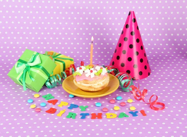 Torta di compleanno colorata con candela e regali su sfondo rosa — Foto Stock