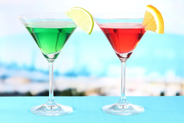 Glasses of cocktails on table near pool — Stock Photo, Image