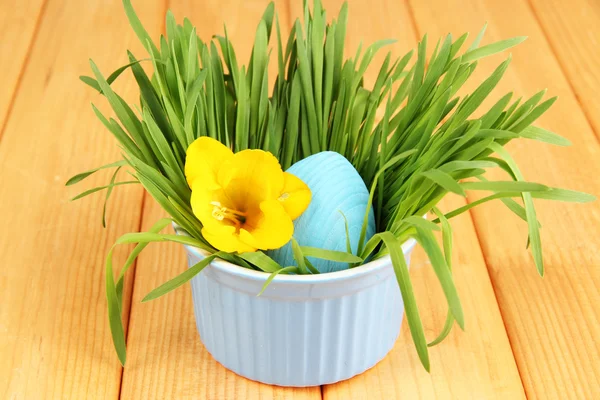 Huevo de Pascua en tazón con hierba sobre mesa de madera de cerca —  Fotos de Stock