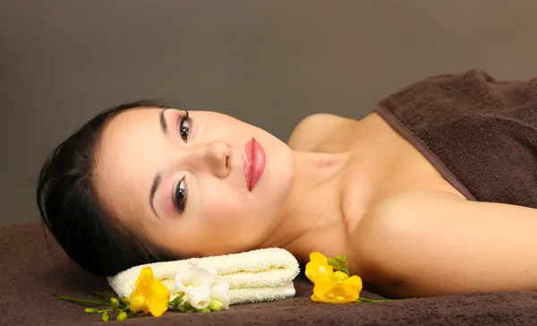 Hermosa joven en el salón de spa, sobre fondo oscuro — Foto de Stock