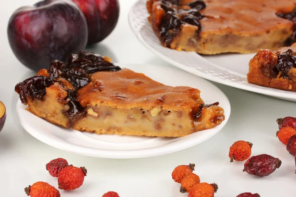 Tasty pie on plate with plums isolated on white — Stock Photo, Image