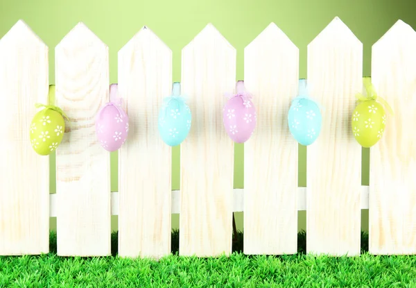 Art Easter background with eggs hanging on fence — Stock Photo, Image