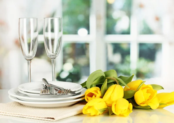 Yellow tulips and utensils for serving on room background — Stock Photo, Image