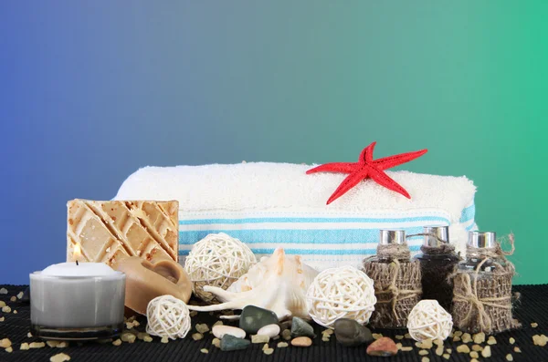 Olie spa, handdoeken kaarsen op houten mat op blauwe achtergrond — Stockfoto