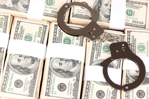 Handcuffs on the packs of dollars close-up — Stock Photo, Image