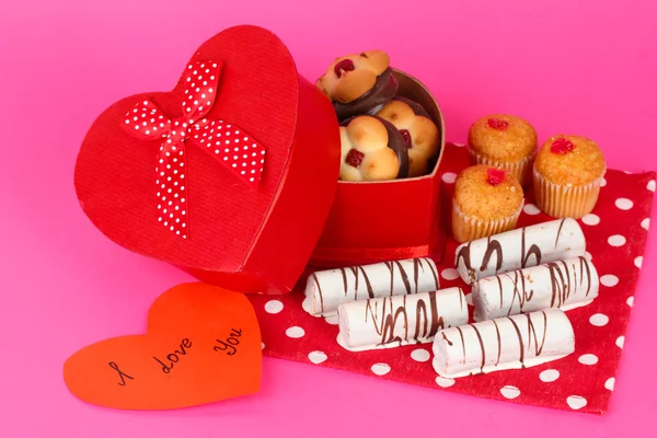 Zoete koekjes in de doos van de gift op roze achtergrond — Stockfoto