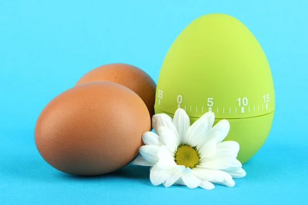 Green egg timer and eggs, on color background — Stock Photo, Image