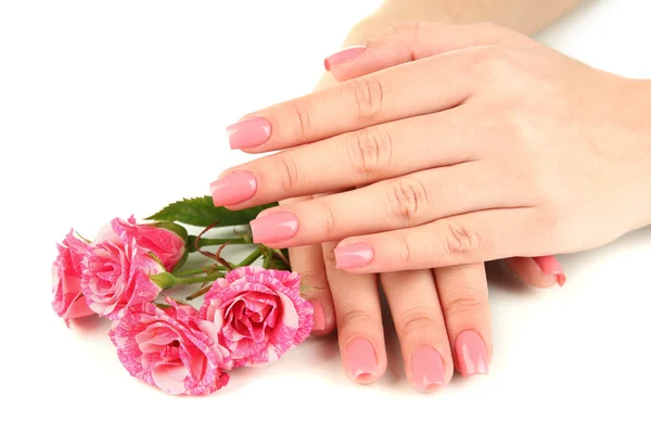 Mãos de mulher com manicure rosa e flores, isoladas em branco — Fotografia de Stock