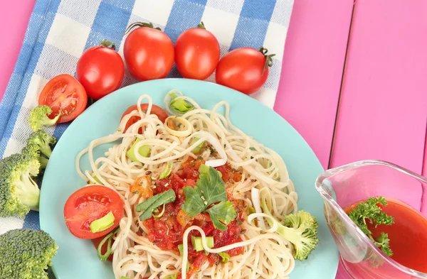 Tasty spaghetti with sauce and vegetables on plate on wooden table close-up — Stock Photo, Image