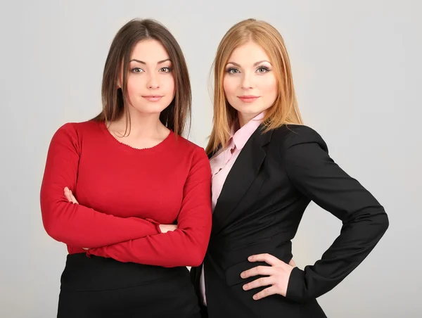 Twee zakelijke vrouwen op grijze achtergrond — Stockfoto