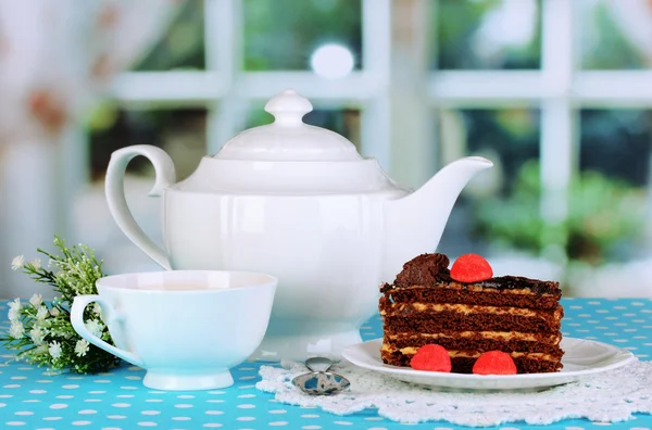 Teiera, tazza di tè e deliziosa torta sullo sfondo della finestra — Foto Stock